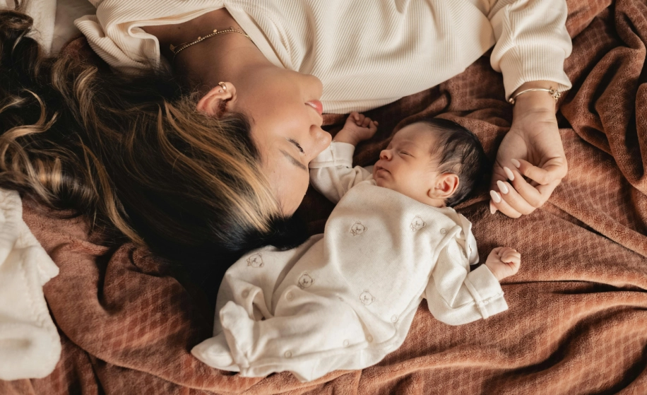 moeder en baby slapend naast elkaar