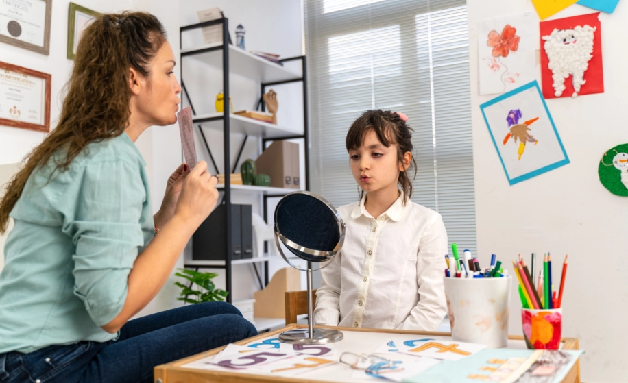 logopediste met meisje aan het oefenen